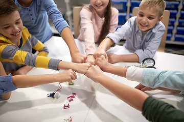 Image showing happy children making fist bump at robotics school