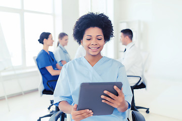 Image showing happy nurse with tablet pc over team at hospital