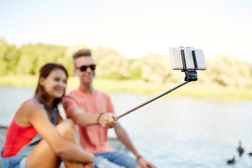 Image showing happy teenage couple taking selfie on smartphone