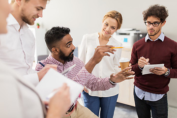 Image showing happy business team discussing something at office