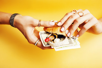 Image showing woman hands holding hamburger with money, jewelry, cosmetic, social issue wealth concept