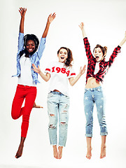 Image showing three pretty young diverse nations teenage girl friends jumping happy smiling on white background, lifestyle people concept 