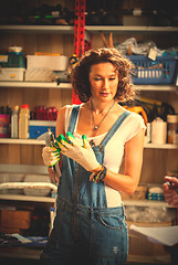 Image showing woman car mechanic in blue overalls declines hand gloves