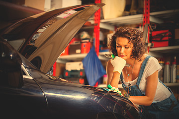 Image showing beautiful woman in overalls auto mechanic with a wrench