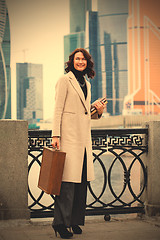 Image showing brunette with a wooden case and books in her hands