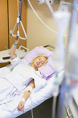 Image showing Bedridden female patient recovering after surgery in hospital care.