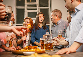 Image showing Group of friends enjoying evening drinks with beer