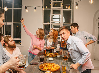 Image showing Group of friends enjoying evening drinks with beer