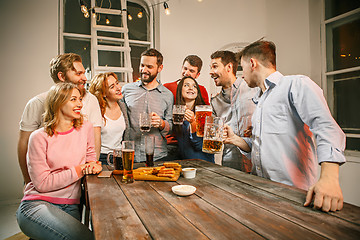 Image showing Group of friends enjoying evening drinks with beer