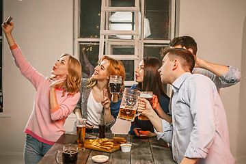 Image showing Group of friends enjoying evening drinks with beer