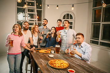 Image showing Group of friends enjoying evening drinks with beer