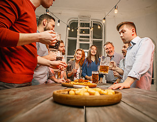 Image showing Group of friends enjoying evening drinks with beer