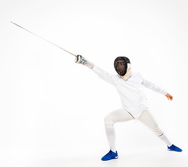 Image showing Man wearing fencing suit practicing with sword against gray