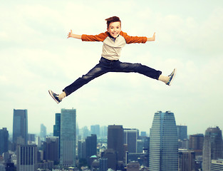 Image showing happy smiling boy jumping in air