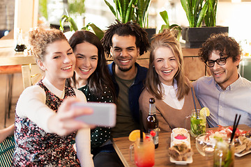 Image showing friends taking selfie by smartphone at bar or cafe