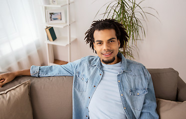 Image showing happy smiling afro american man on sofa at home