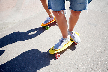 Image showing teenage couple riding skateboards on city road