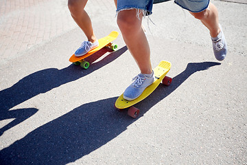 Image showing teenage couple riding skateboards on city road