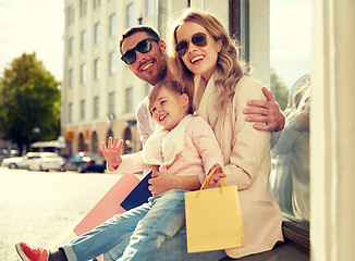 Image showing happy family with child and shopping bags in city