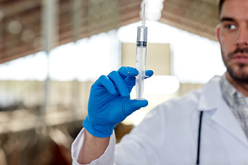 Image showing veterinarian hand with vaccine in syringe on farm