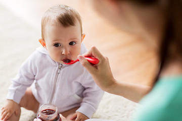 Image showing mother with spoon feeding little baby at home