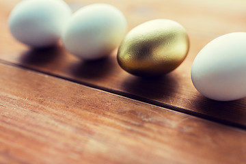 Image showing close up of golden and white easter eggs on wood