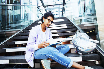 Image showing young cute indian girl at university building sitting on stairs 