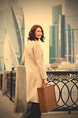 Image showing fashion. beautiful smiling brunette in a bright coat 