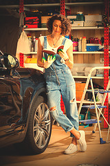 Image showing car mechanic, a beautiful woman studying the instructions for re