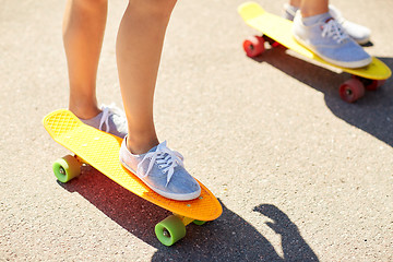 Image showing close up of female feet riding short skateboard