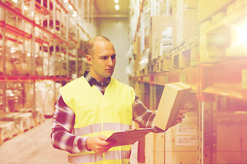 Image showing man with clipboard in safety vest at warehouse