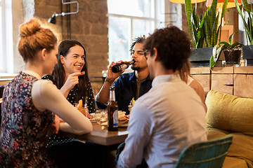 Image showing happy friends eating and drinking at bar or cafe