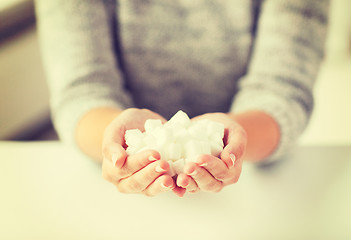 Image showing close up of white lump sugar in woman hands