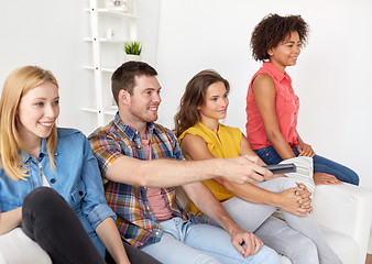 Image showing happy friends with remote watching tv at home