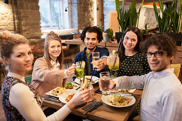 Image showing happy friends with drinks and food at restaurant