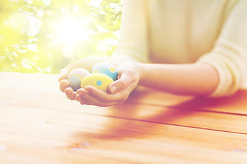 Image showing close up of woman hands with colored easter eggs