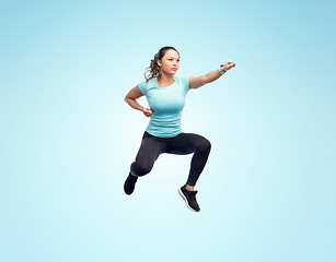 Image showing happy sporty young woman jumping in fighting pose