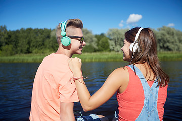 Image showing teenage couple with headphones on river berth