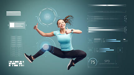 Image showing happy sporty woman jumping and showing thumbs up 