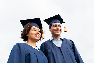 Image showing happy students or bachelors in mortarboards