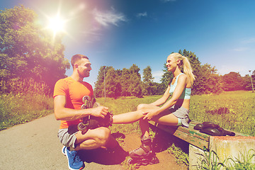 Image showing happy couple with rollerblades outdoors