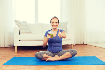 Image showing woman with smoothie showing thumbs up at home