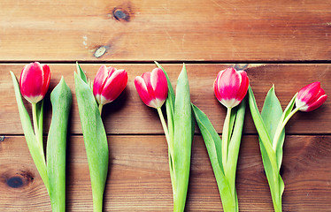 Image showing close up of red tulip flowers on wooden table