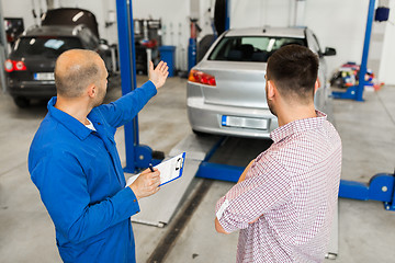 Image showing auto mechanic with clipboard and man at car shop