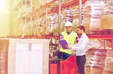 Image showing worker and businessmen with clipboard at warehouse