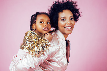 Image showing young pretty african-american mother with little cute daughter hugging, happy smiling on pink background, lifestyle modern people concept 