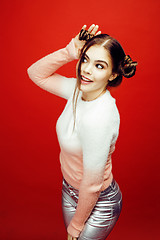 Image showing young pretty emitonal posing teenage girl on bright red background, happy smiling lifestyle people concept 