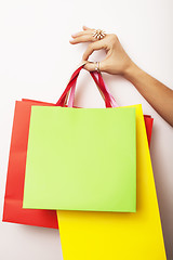 Image showing woman hand holding few paper bags on white background isolated, shopping sale concept