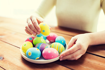 Image showing close up of woman hands with colored easter eggs