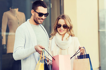 Image showing happy couple with shopping bags at shop window